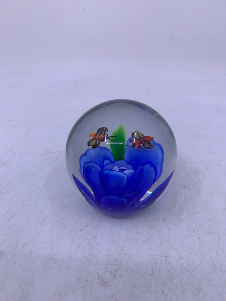 BLOWN GLASS SPHERE W/ BLUE FLOWER BEES FLYING ABOVE IT.