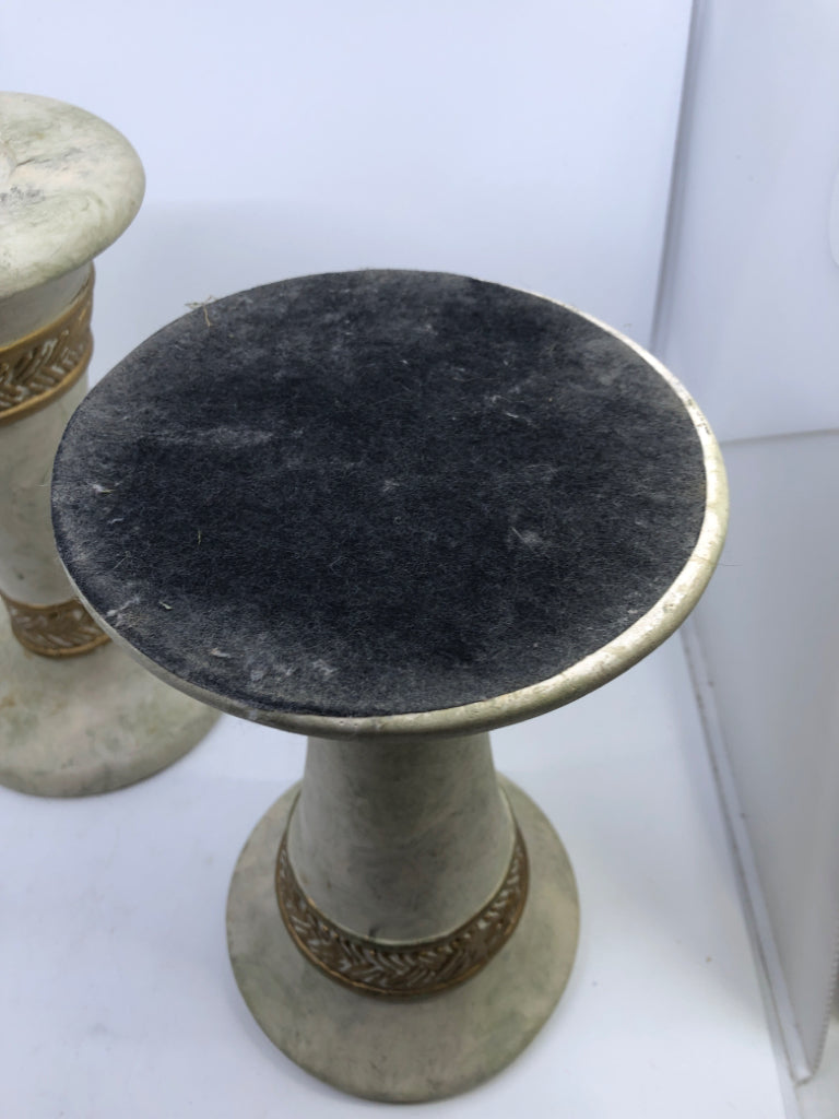 2 WHITE STONE W/GOLD DETAIL PILLAR CANDLE HOLDERS.