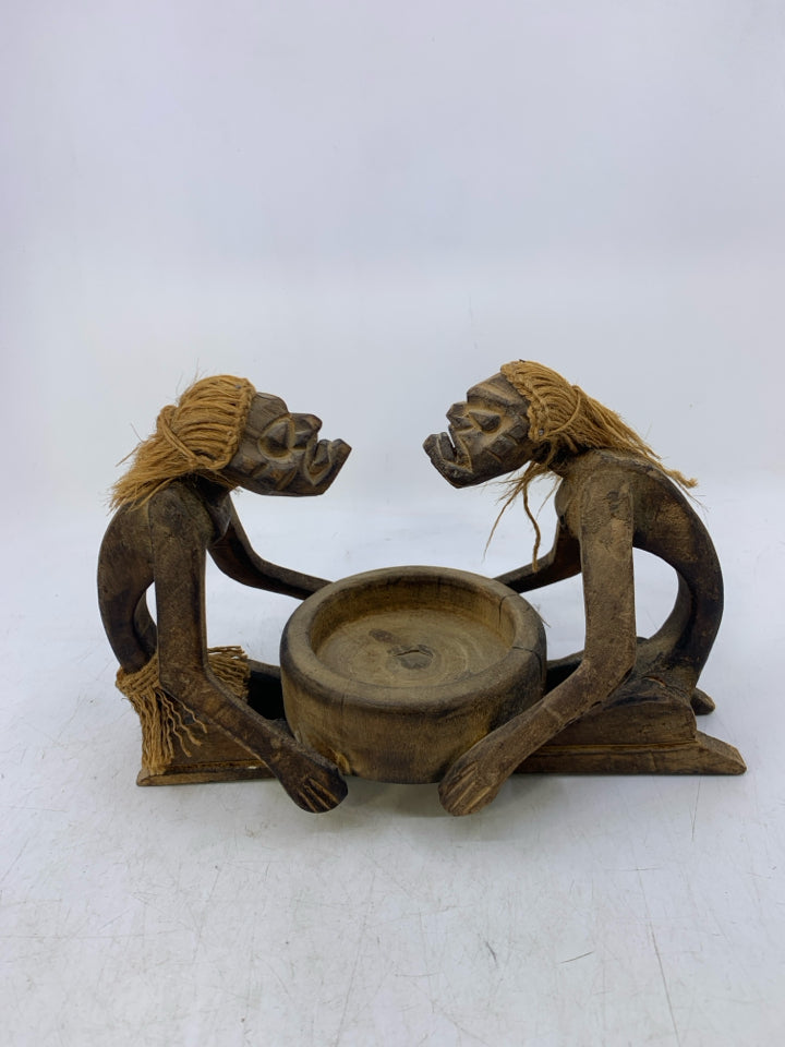 CARVED MEN LOOKING AT EACHOTHER KNEELING W/ BOWL.