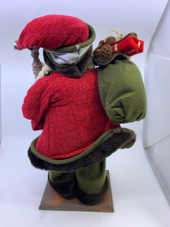 GREEN SANTA WITH DEER POLE HOLDING SACK.