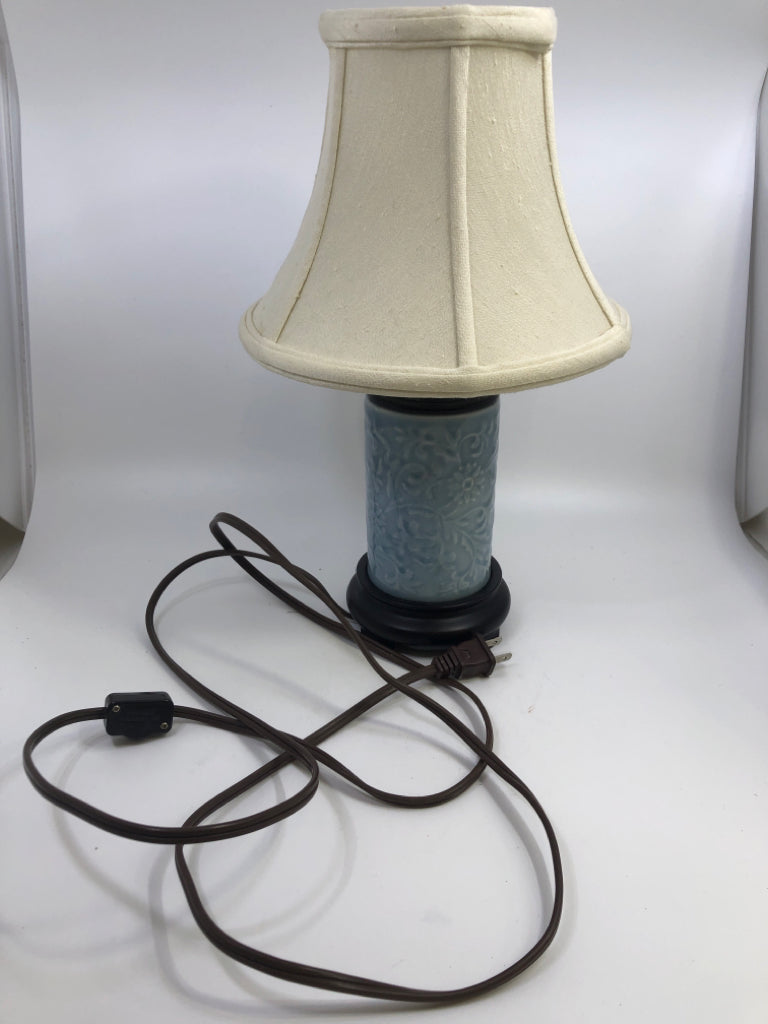 SMALL CERAMIC TABLE LIGHT BLUE LAMP W/WOODEN BASE AND CREAM COLORED SHADE.