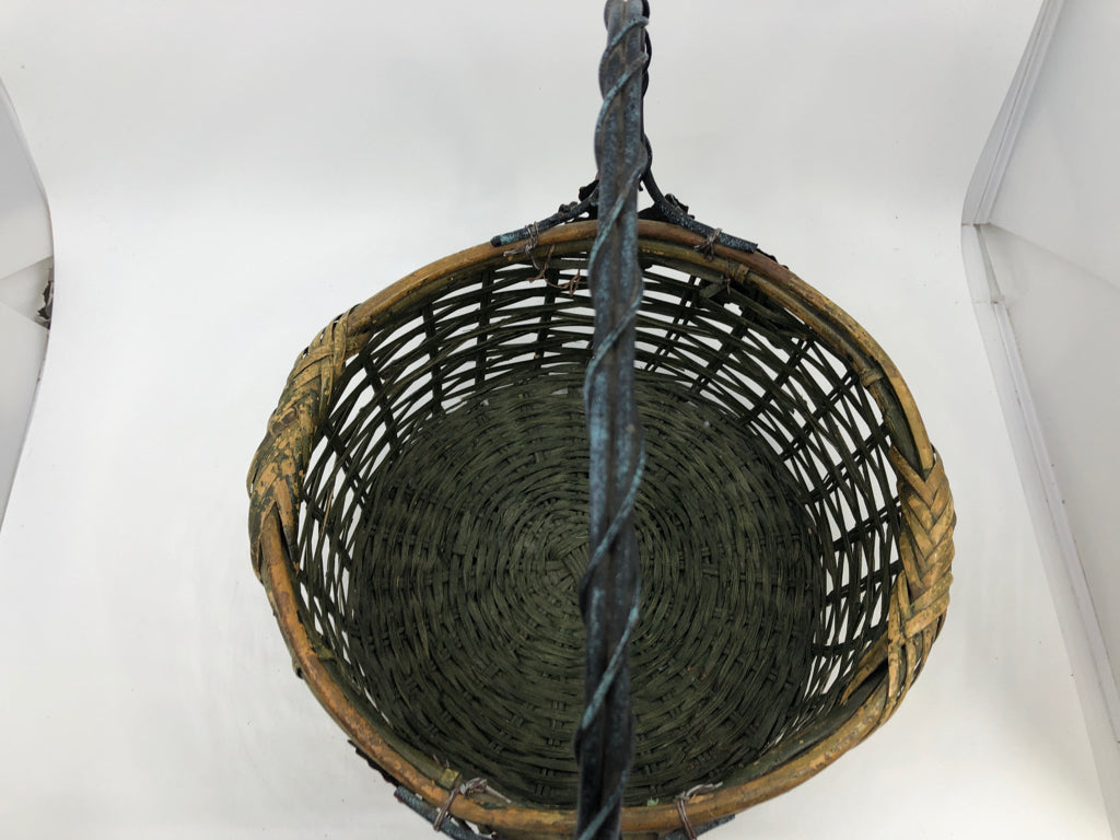 GREEN WOVEN BASKET W METAL HANDLE AND LEAVES.