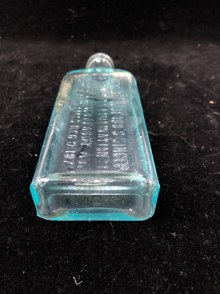 EMPTY LIGHT BLUE GLASS BOTTLE W/ WRITING.