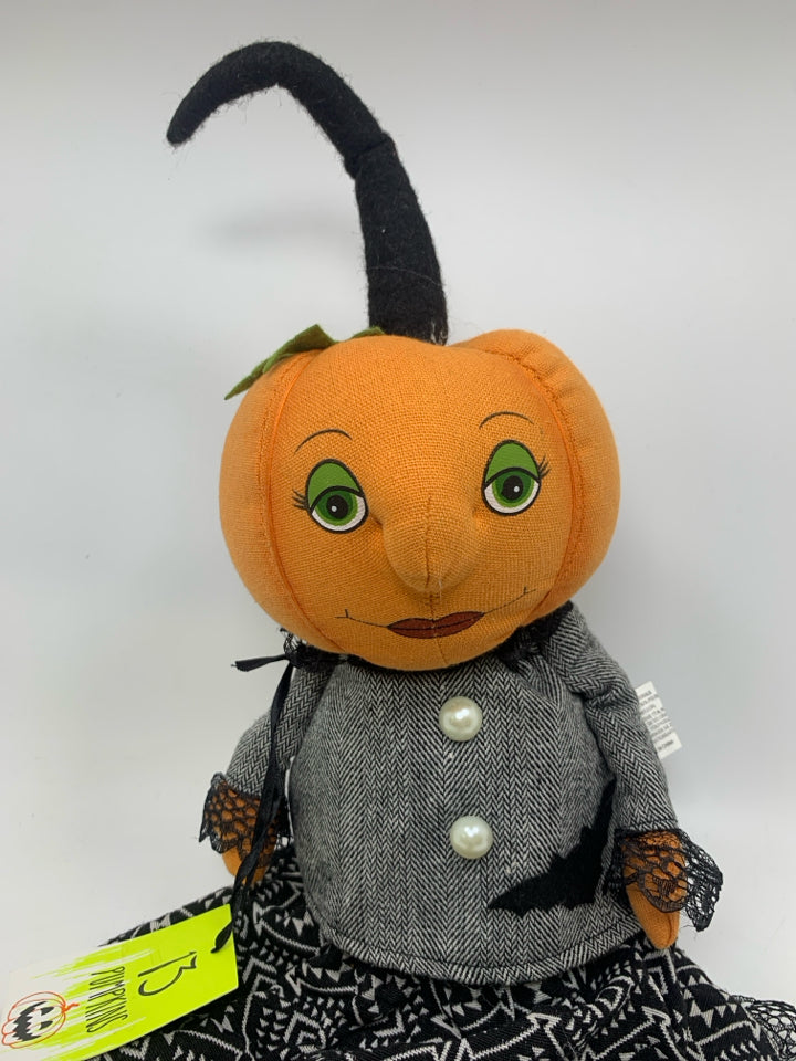PLUSH PUMPKIN DOLL IN BLACK DRESS.