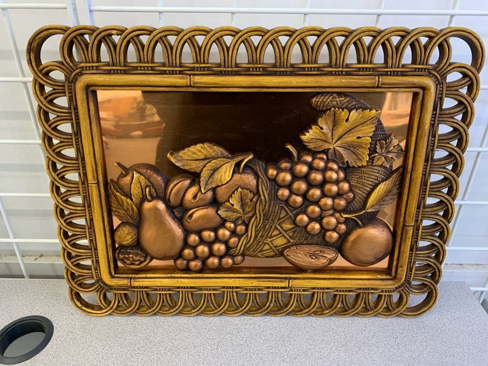 VTG BRONZE FRUIT IN WOVEN PLASTIC FRAME, COPPER BACKGROUND.