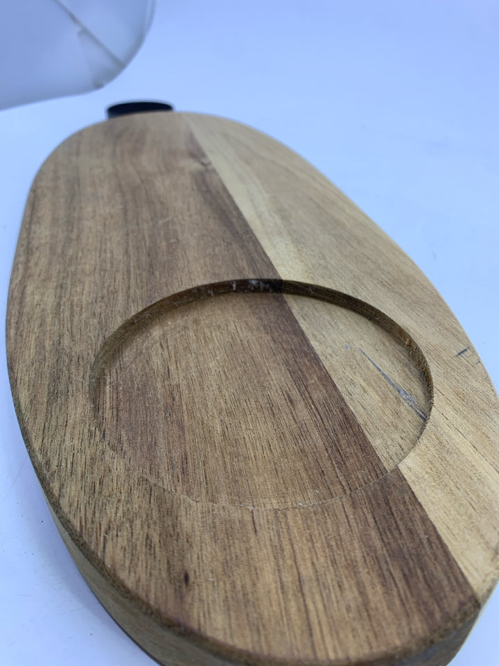 OVAL WOOD CUTTING BOARD WITH BLACK METAL HANDLE.