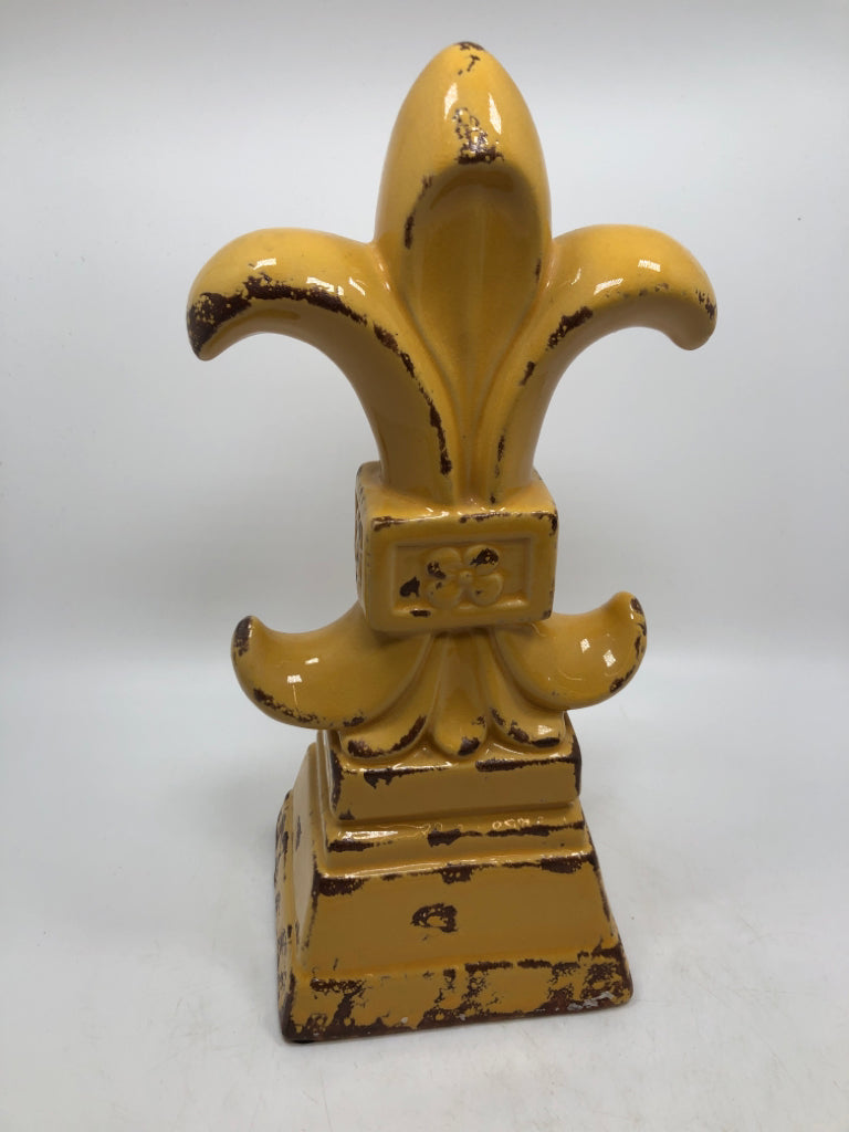 YELLOW FLEUR-DE-LIS FIGURINE.