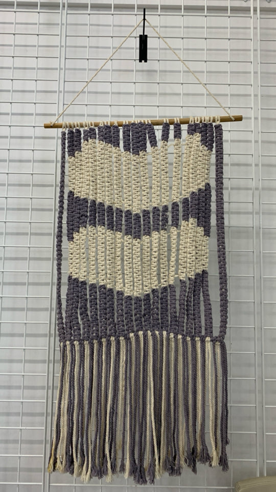 CREAM AND PURPLE MACRAME WALL HANGING ON DOWEL ROD.