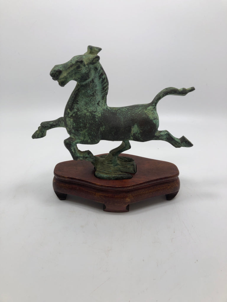 METAL JUMPING HORSE ON WOOD BASE.