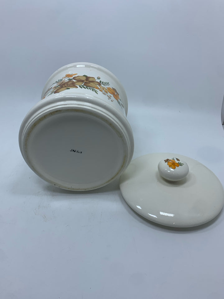 WHITE CERAMIC CANISTER W/BROWN AND ORANGE FLOWERS.