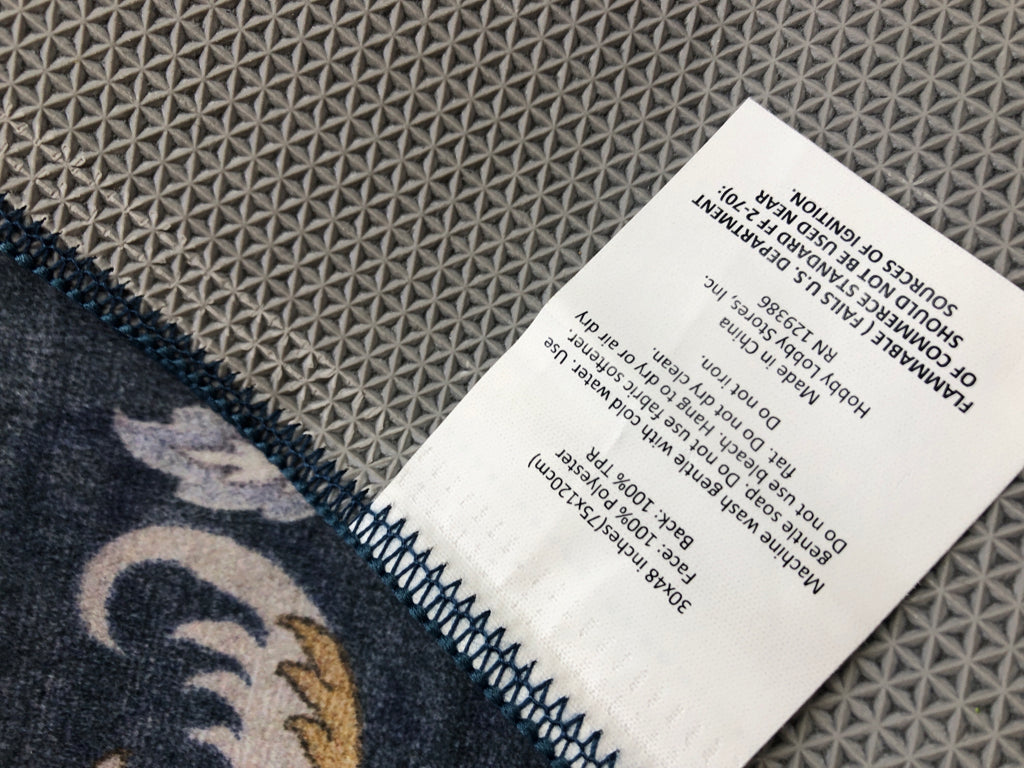 THIN BLUE FLORAL RUG W/YELLOW PETALS.