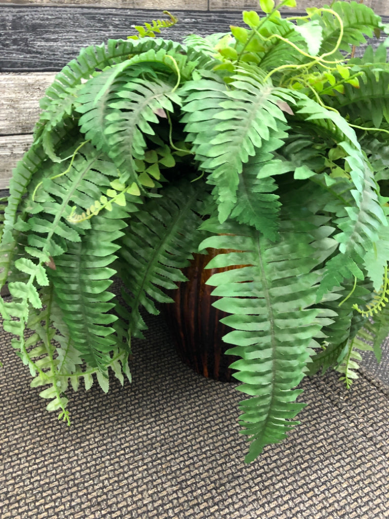 FAUX FERN IN BROWN CERAMIC PLANTER.