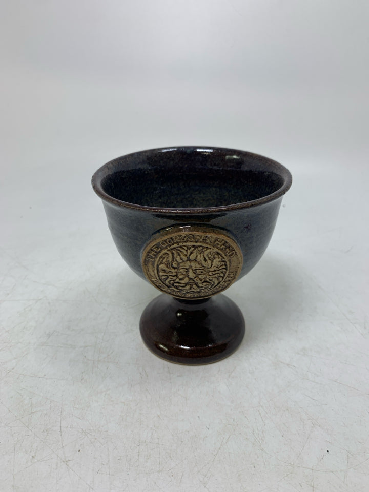 SHORT FOOTED POTTERY GOBLET W/ THE GORGONS HEAD MEDALLION IN CENTER.
