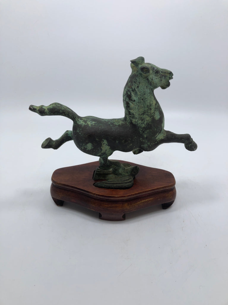 METAL JUMPING HORSE ON WOOD BASE.
