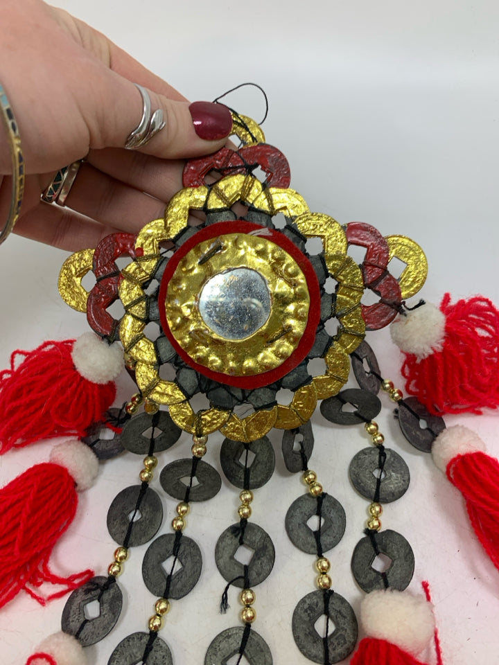 HANGING ABSTRACT METAL MEDALLIONS W/ RED TASSELS.