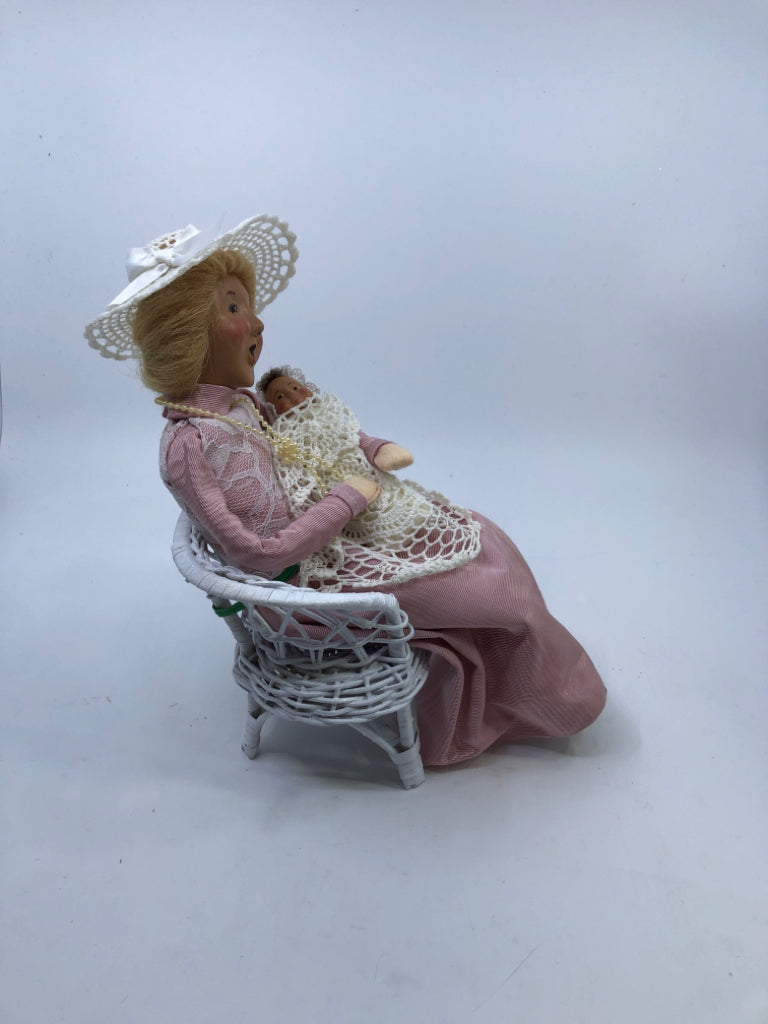 BYERS' CHOICE WOMAN HOLDING BABY SITTING IN CHAIR.