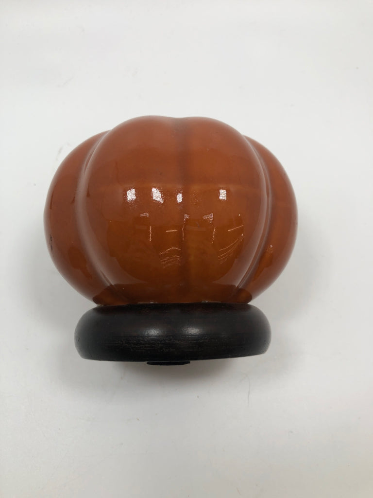 ORANGE CERAMIC PUMPKIN TEALIGHT HOLDER ON WOOD PEDESTAL.