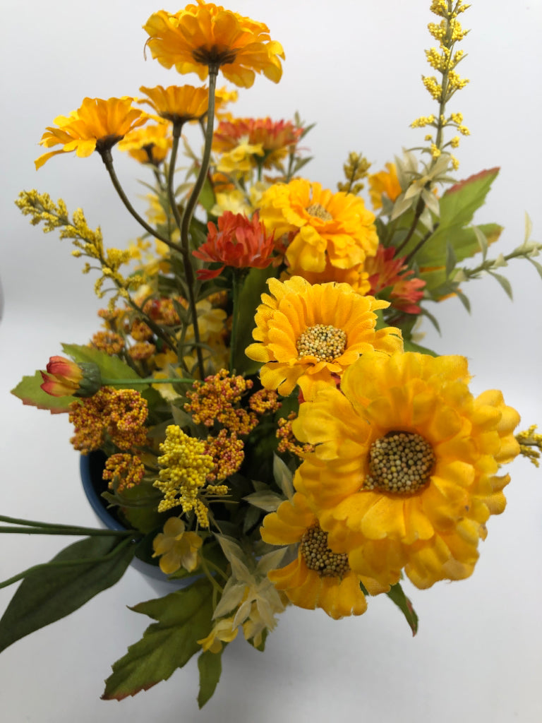 YELLOW FAUX FLOWERS IN BLUE PLANTER.