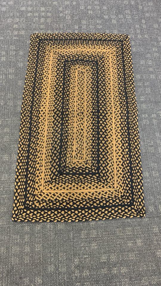 BLACK/BEIGE BRAIDED WOVEN RUG.