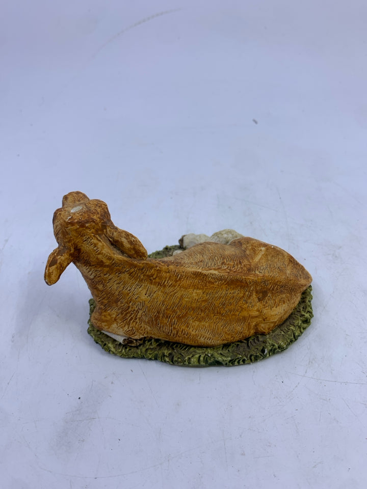 CERAMIC SITTING LIGHT BROWN/WHITE COW ON GRASS.