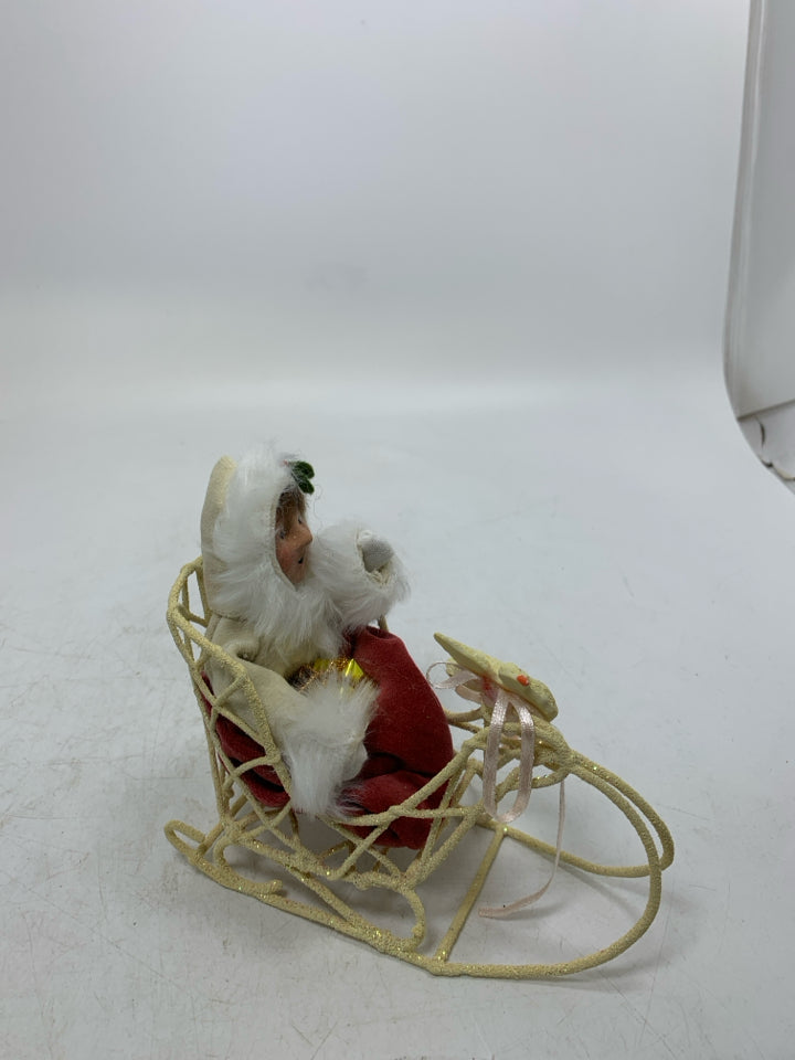 VTG BYER'S CHOICE GIRL IN SLED HOLDING PRESENT CAROLER.