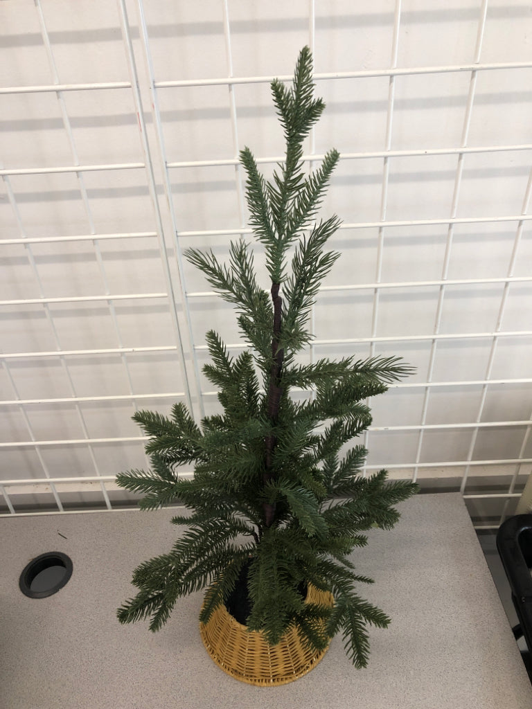 FAUX PINE TREE IN WICKER BASKET.