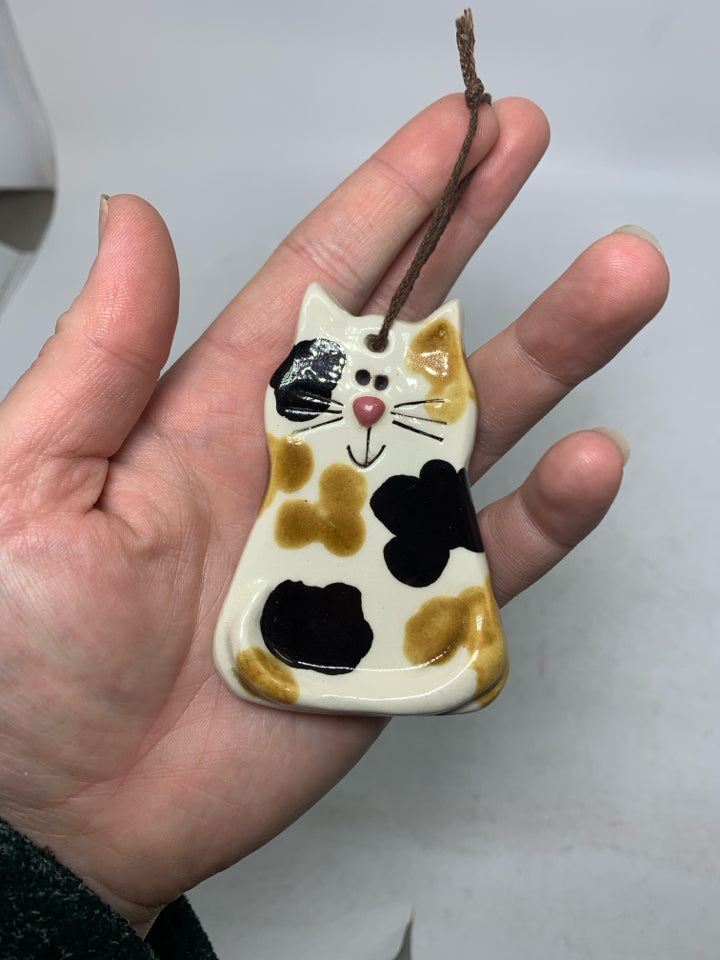 SMALL SPOTTED POTTERY CAT FIGURINE IN BAG.