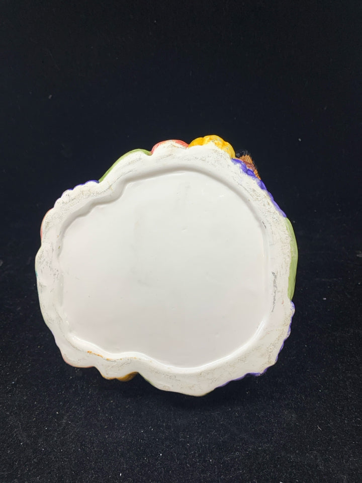 COLORFUL TURKEY BOWL SITTING ON FOOD.