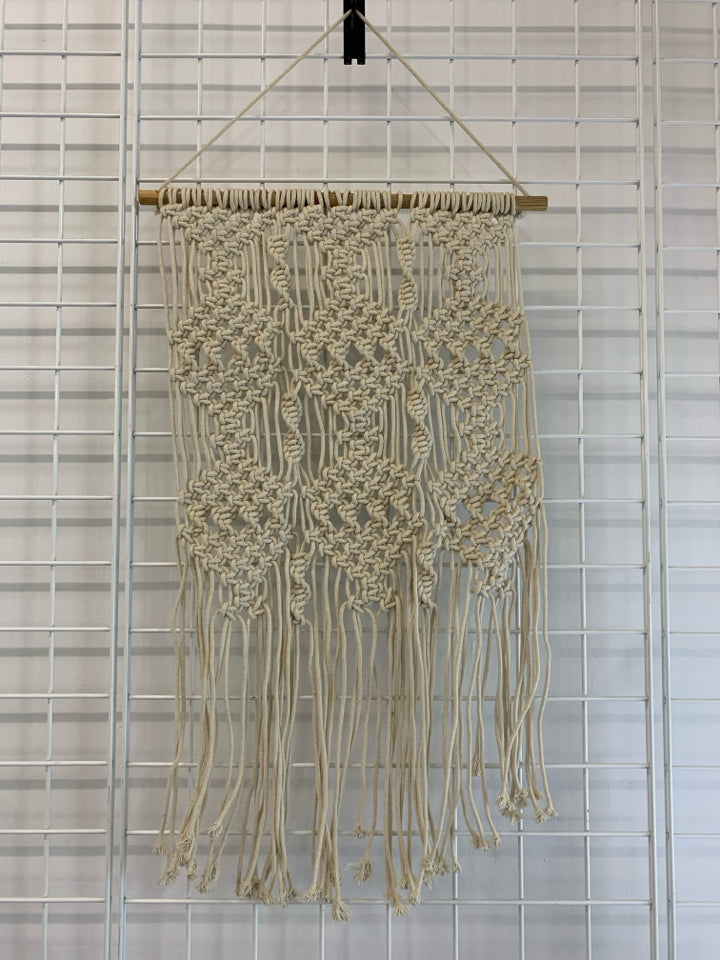 CREAM MACRAME WALL HANGING ON DOWEL ROD.