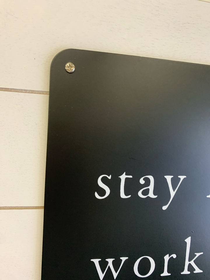 STAY HUMBLE WORK HARD KIND METAL CUT-OUT SIGN ON WHITE WOOD.