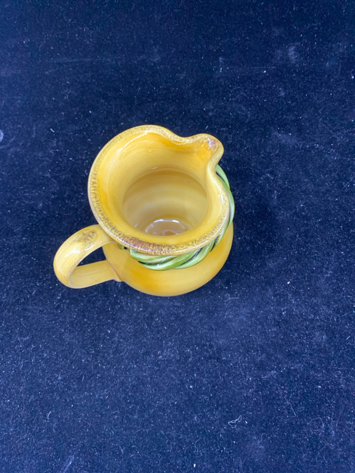 YELLOW POTTERY CREAMER W/ GREEN ROPE DETAIL.