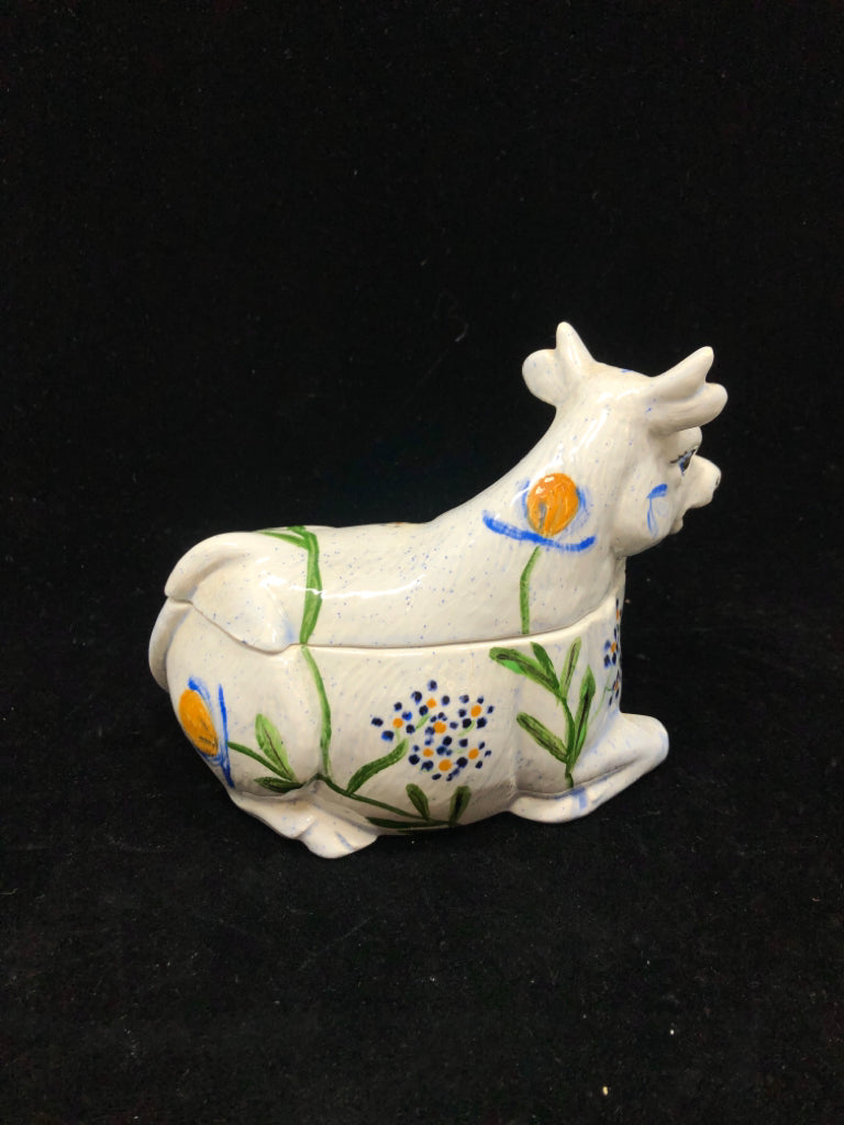 CERAMIC COW CANISTER W/BLUE & YELLOW FLORAL MOTIFS.