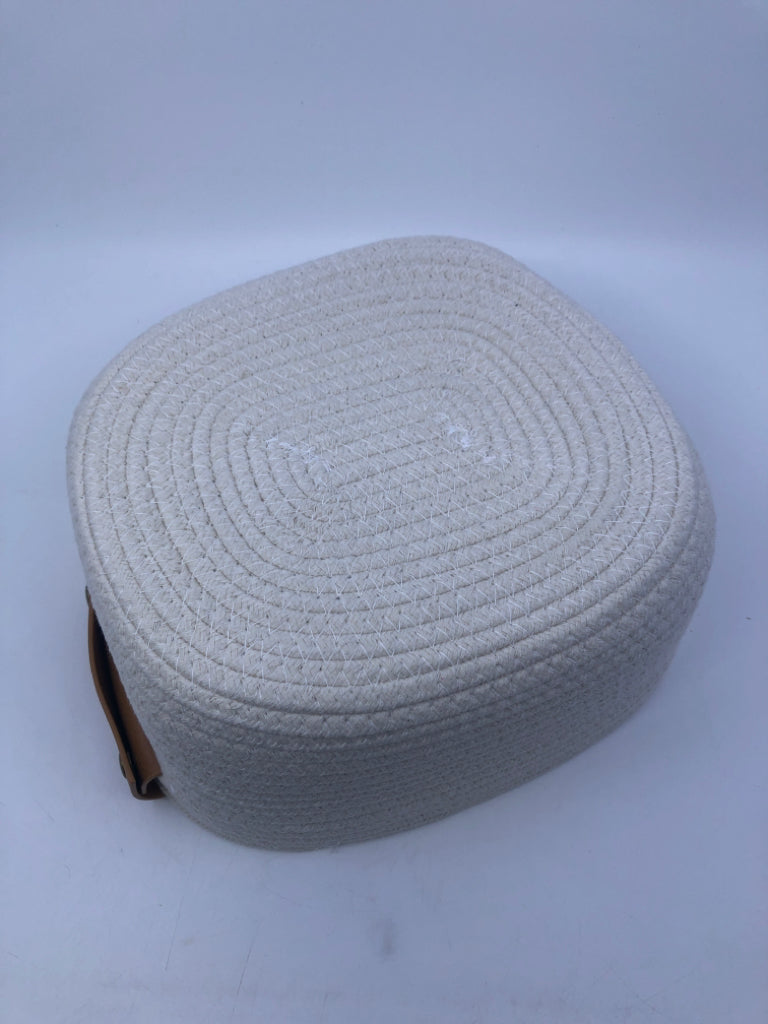 CREAM WOVEN FABRIC BASKET W FAUX LEATHER HANDLES.