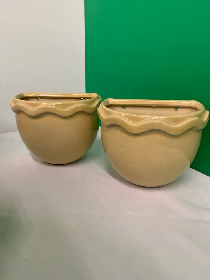 2 TAN CERAMIC WALL HANGING PLANTERS.