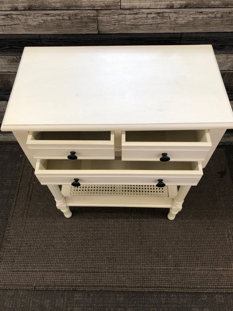 WHITE WOOD SIDE TABLE W/3 DRAWERS AND CANE BOTTOM SHELF.