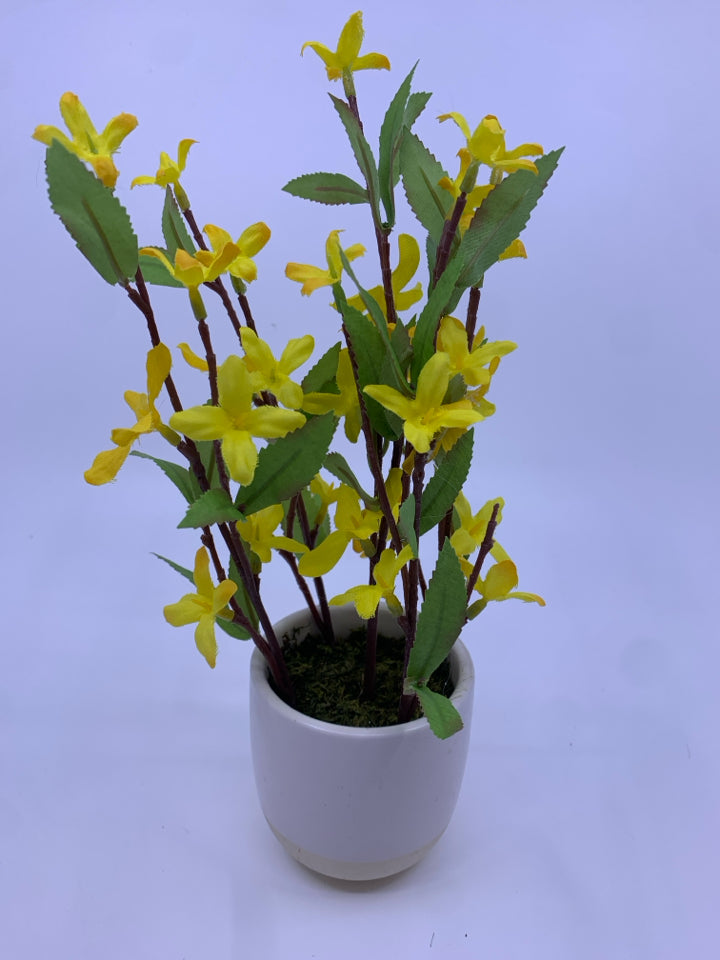 FAUX YELLOW FLOWERS IN WHITE PLANTER.