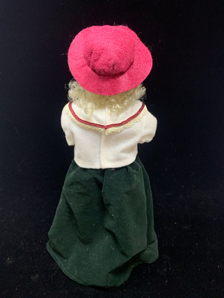 OLDER WOMAN SINGING CAROLER W/RED HAT.