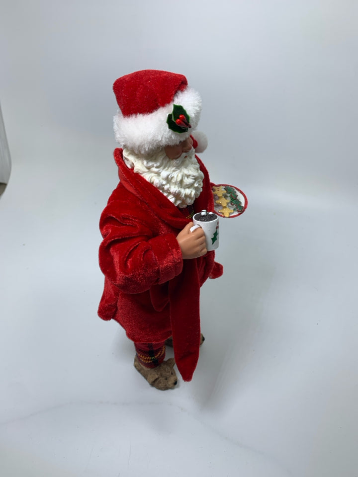 STANDING SANTA IN PJS HOLDING COCOA & COOKIES.