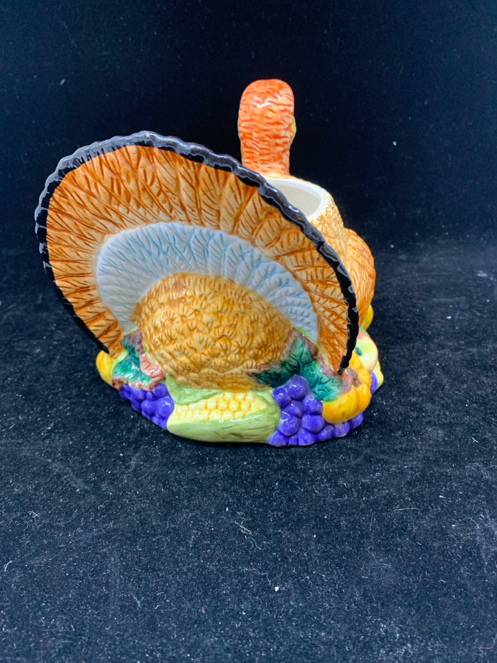 COLORFUL TURKEY BOWL SITTING ON FOOD.