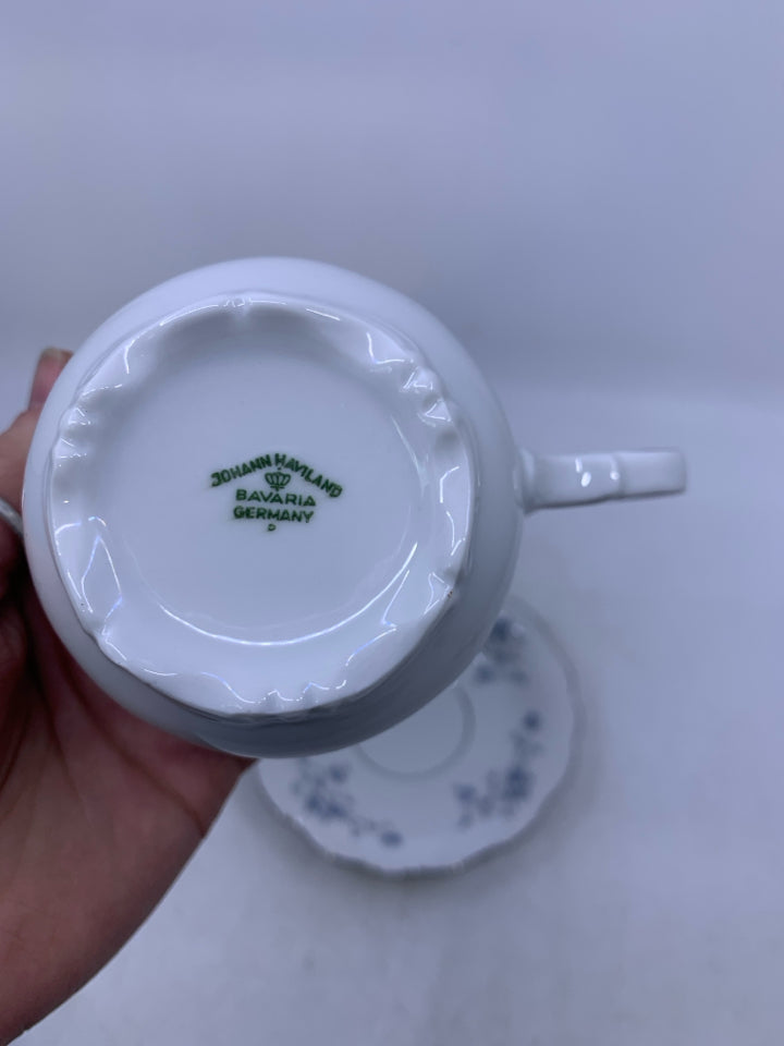 WHITE TEA CUP W/ BLUE FLOWERS & SILVER DETAILS.