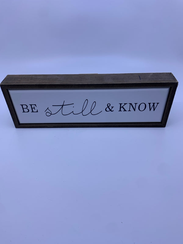 "BE STILL" BLACK LETTERS WHITE BACKGROUND WALL ART.