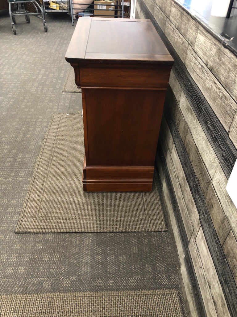 DARK CHERRY SIDE TABLE W/VTG METAL HANDLES & GLASS COVER ON WHEELS.