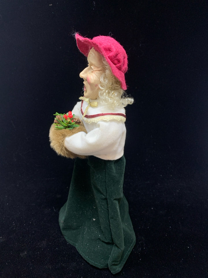 OLDER WOMAN SINGING CAROLER W/RED HAT.