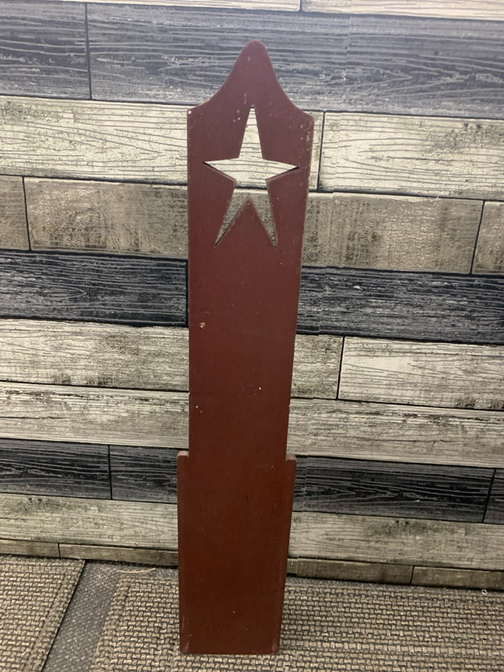 RED PRIMITIVE CANDLE HOLDER W STAR CUT OUT.