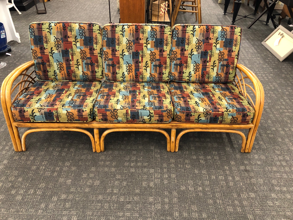 RATTAN SOFA W/PATTERNED FABRIC.