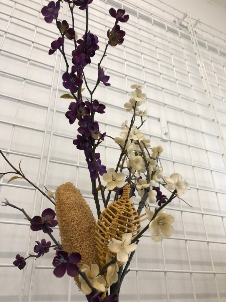 PURPLE FLORALS IN BLUE GLASS VASE.