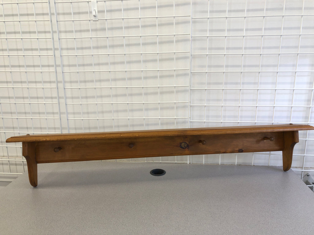 LIGHT BROWN WALL SHELF W/ COAT HOOKS.