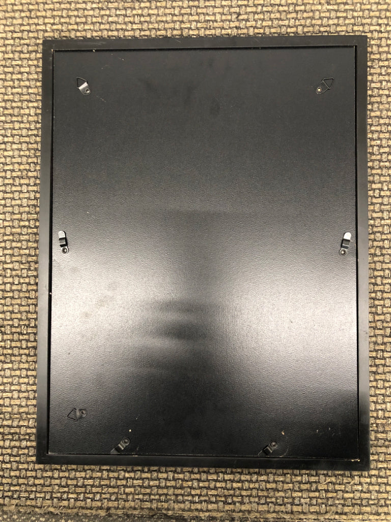 BLACK/WHITE FLOWER WATERING CAN PRINT IN BLACK FRAME.
