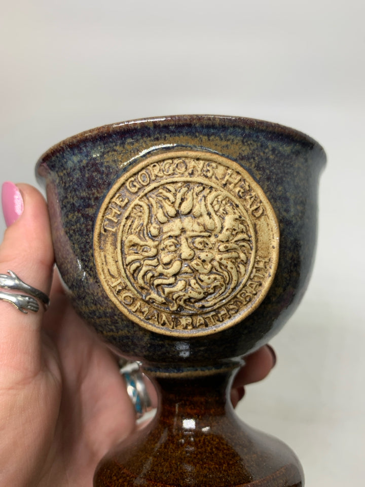 SHORT FOOTED POTTERY GOBLET W/ THE GORGONS HEAD MEDALLION IN CENTER.