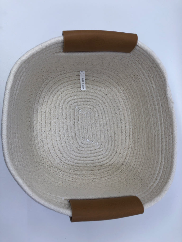 CREAM WOVEN FABRIC BASKET W FAUX LEATHER HANDLES.